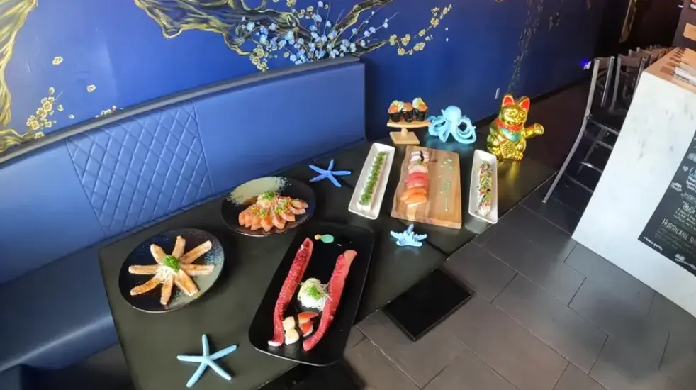 Chef preparing custom sushi rolls at BluWave Sushi