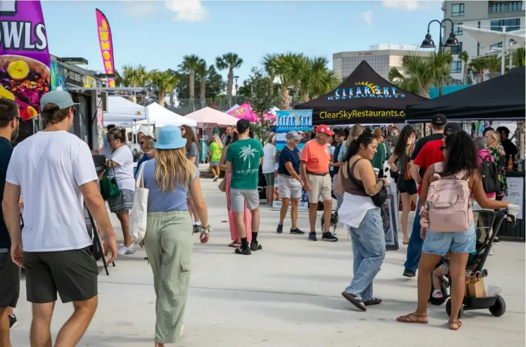 Shoppers enjoying the vibrant atmosphere of Market Marie at Coachman Park.